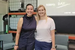 Portrait of Sarah Fleischer and her co-founder Dr. Ksenija Milicevic Neumann at the tozero Day. In the background you can see a screen with a presentation about tozero. 